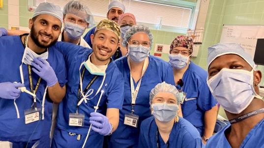 Dr. Abdulrahaman Alotaibi, Dr. Andrew Giles, Dr. Wiley Chung and Dr. Kirsten Nesset (Left) pose with members of the OR team that worked together on the case, showing off the pin after it was successfully removed.